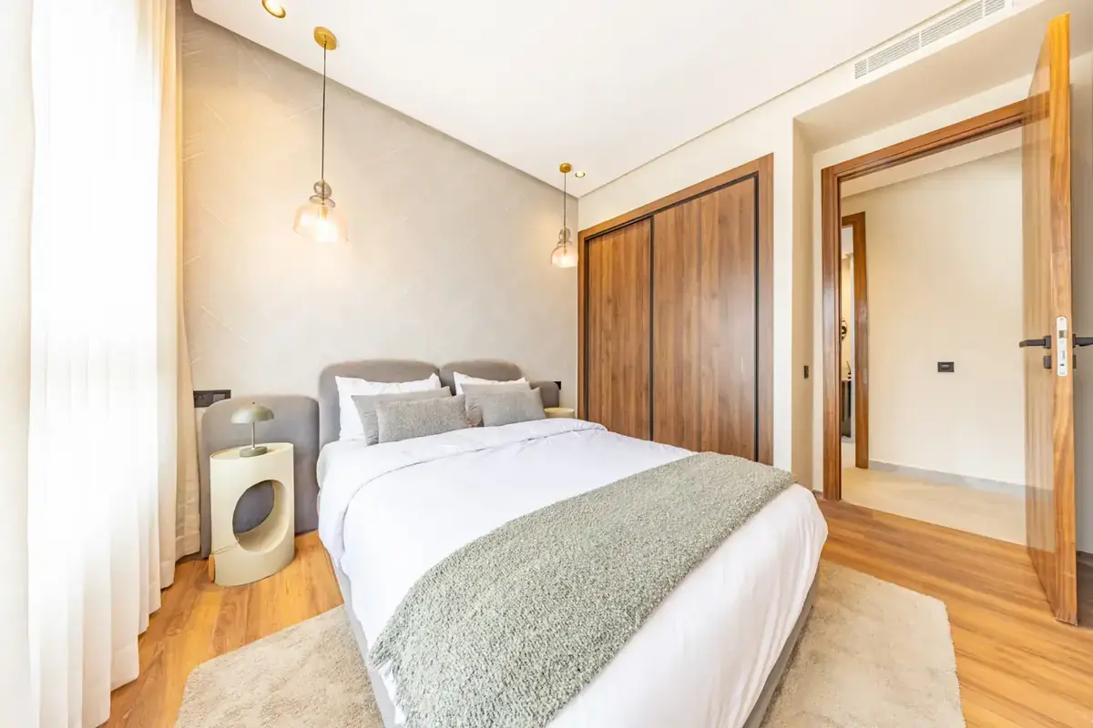 Neutral bedroom with wooden wardrobes and pendant lighting
