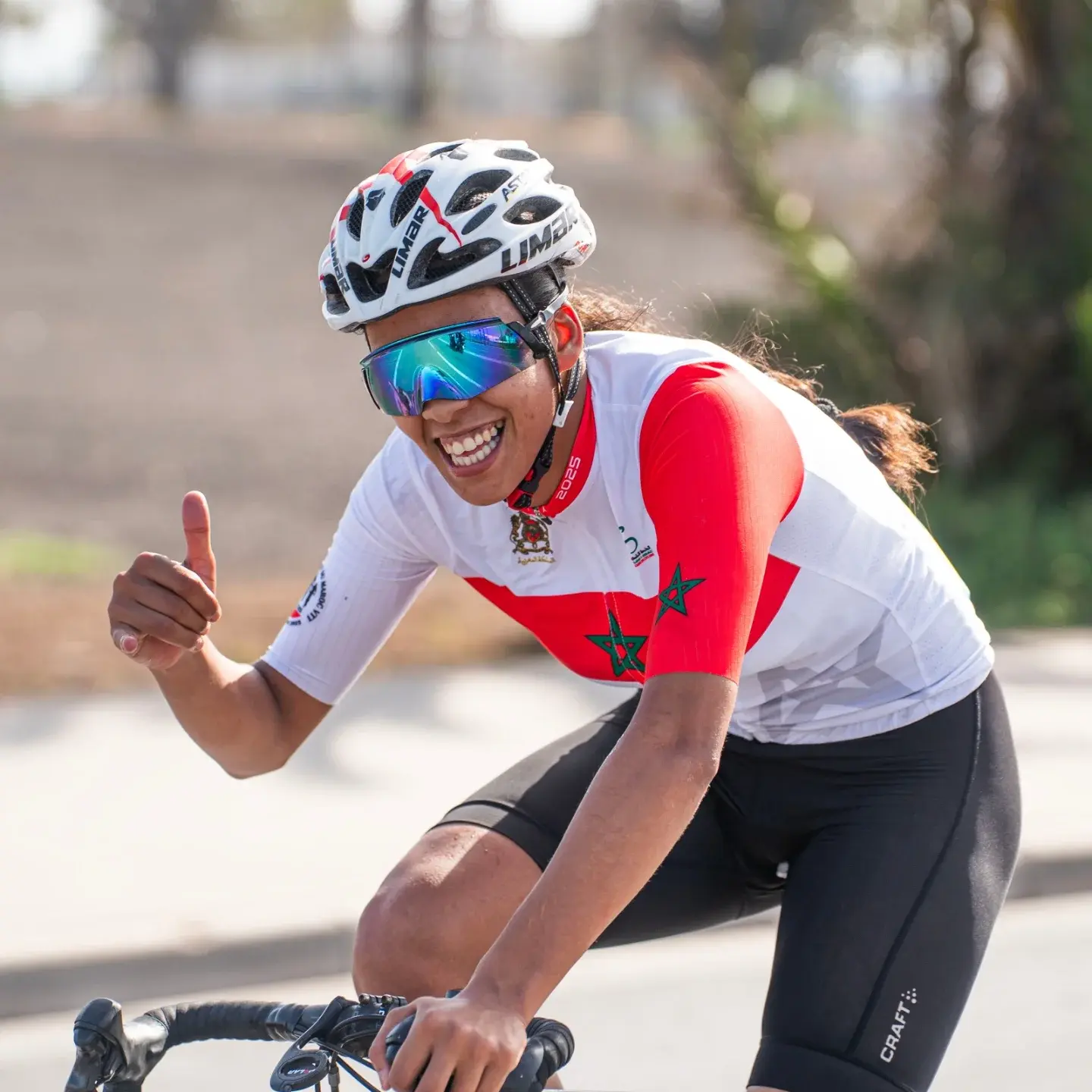 Moroccan national champion smiling and giving a thumbs-up while racing